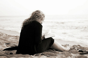 immagine di donna che legge sulla spiaggia - 